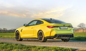 Żółte BMW M4 Competition na tle zachodzącego słońca. Sprawdź aktualną bmw m4 competition cena.