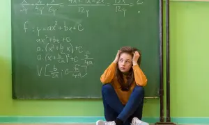 Dziewczyna zmagająca się z zadaniami matematycznymi na tablicy, symbolizująca dyskalkulię u dorosłych.