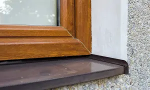 Zastanawiasz się, czym pomalować parapet zewnętrzny z blachy ocynkowanej? Ten brązowy parapet przy drewnianej ramie okna wygląda świetnie.