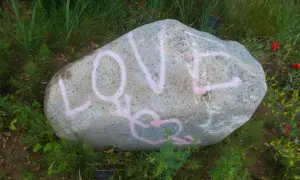 Duży kamień z różowym napisem LOVE i sercem.