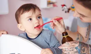 Mama podaje dziecku witaminę D na łyżeczce. Ważne jest, ile witaminy D dla 2 latka, by zapewnić mu zdrowy rozwój.