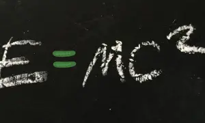Równanie E=mc² napisane kredą na czarnej tablicy.