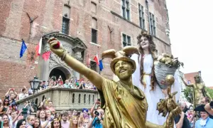 Złoci aktorzy na jarmarku świętego dominika w Gdańsku, tłum widzów z aparatami.