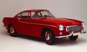 Une élégante Volvo rouge, un modèle emblématique des années 50, se dresse fièrement sur un fond neutre.