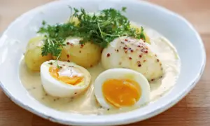 Eier in Senfsauce, ein klassisches Rezept von Mutti, serviert mit Kartoffeln und Kresse.