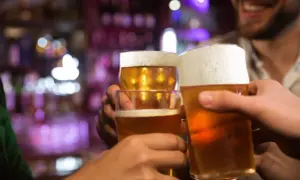 Brindisi con birra in un locale. Forse dopo un bicchiere, la birra fa dormire bene.