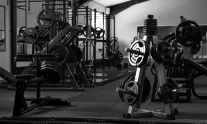 Máquinas de gimnasio con pesas y barras en un gimnasio.