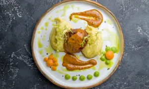Talerz z pieczoną wieprzowiną, puree ziemniaczanym i sosami.