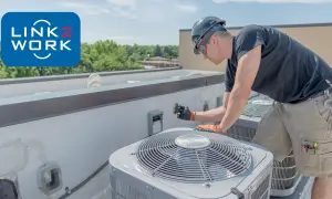 Doświadczony monter wentylacji pracuje na dachu, naprawiając jednostkę klimatyzacyjną.