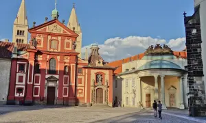 Visite à Prague : la place pavée devant la basilique Saint-Georges et le monastère, avec des touristes se promenant sous un ciel bleu.