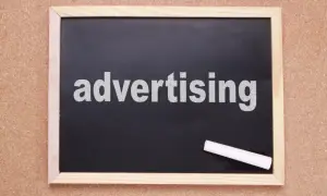 Tablica z napisem "advertising" i kredą. Czas na rymowane hasła reklamowe, które przyciągną uwagę!