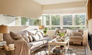 Salón luminoso con sofá y sillones en tonos neutros. La paleta de colores para pintar salones es cálida y acogedora, inspirada en la luz natural.