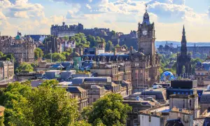 Edinburghs Skyline mit Schloss und Uhrenturm. Die beste Reisezeit für dieses Panorama ist im Sommer, wenn die Bäume grün sind.