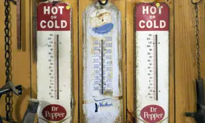 Trzy stare termometry wiszą na drewnianej ścianie. Dwa z nich reklamują Dr Pepper, jeden pokazuje "Ay Weather's". Idealne do monitorowania temperatury w biurze.