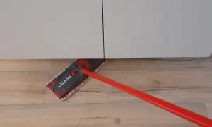 Mocio Vileda rosso pulisce il pavimento in legno, mostrando come smacchiare il legno con facilità.