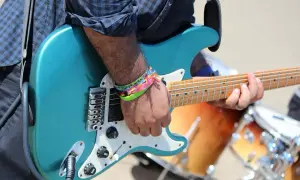 Ręka grającego na gitarze z kolorowymi bransoletkami, nie nie nie, to muzyka!