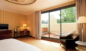 Habitación de lujo con terraza privada y tumbonas, ideal para relajarse tras un día en el spa Westin Valencia.