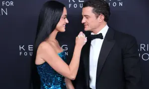 Katy Perry i Orlando Bloom patrzą na siebie z czułością. Ona w błyszczącej sukni, on w eleganckim smokingu.