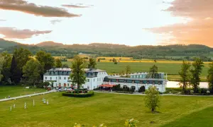 Das Schlosshotel Wernersdorf, ein prachtvolles Anwesen, liegt eingebettet in eine malerische Landschaft mit Feldern und Hügeln.