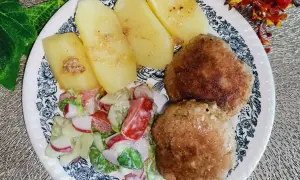 Dwa kotlety mielone z majonezem, ziemniaki i surówka z rzodkiewki i pomidora.