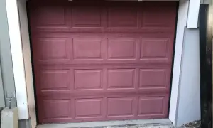 En mörkröd garageport i aluminium, redo att måla om för ett fräschare utseende.