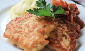 Två gyllene havets wallenbergare serveras med krämigt potatismos och glaserade morötter, toppat med en kvist persilja.