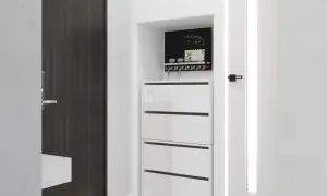 Biały, nowoczesny regał na buty z trzema szufladami, nad którym znajduje się tablica z napisem "welcome home!" i wieszak na klucze.