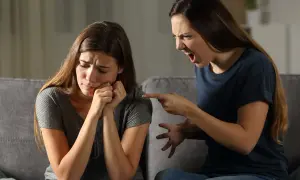 Una sorella urla e punta il dito contro l'altra, che piange. Litigi tra sorelle adulte.