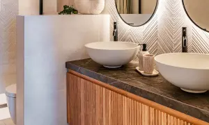 Modernos cuartos de baños con lavabos sobre encimera, grifería negra y detalles en madera.