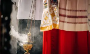 Złota kadzielnica unosi dym podczas uroczystości. W tle widać szaty liturgiczne, przypominające o święta nakazane.
