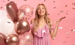 Radosne życzenia urodzinowe dla bratowej! Uśmiechnięta blondynka w różowej sukience, otoczona balonami i konfetti.