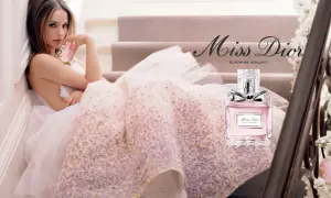 Kobieta w tiulowej sukni trzyma flakonik Miss Dior Blooming Bouquet.