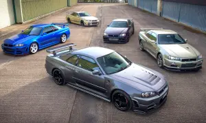 Pięć kultowych Nissanów GT-R R34 w różnych kolorach, stojących na betonowym placu.