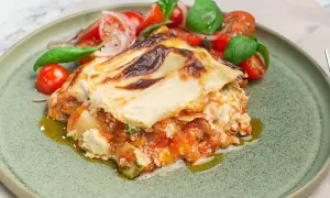 En bit krämig pesto lasagne med en fräsch tomatsallad.