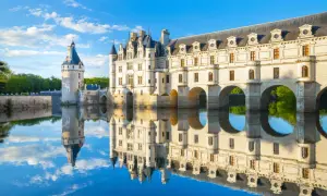 Le château de Chenonceau se reflète dans l'eau, un lieu idéal pour une visite paisible.