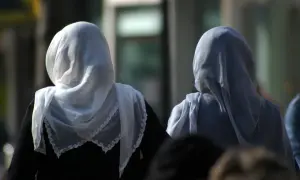 Dwie kobiety w hidżabach, symbolizujące tradycję i to, czego nie wolno kobietom w Turcji, idą ulicą.