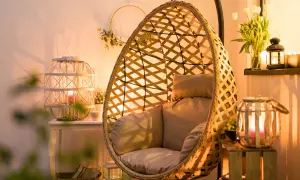 Przytulny salon z fotelem wiszącym i lampionami w aranżacjach tworzącymi ciepłą atmosferę.