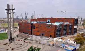 Zwiedzanie Stoczni Gdańskiej: nowoczesny budynek ECS i historyczne dźwigi portowe.