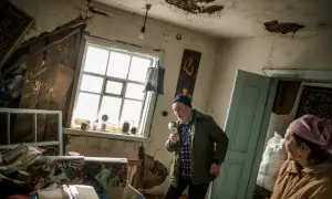 Wojciech Grzedzinski uchwycił moment, gdy mężczyzna w zniszczonym pokoju trzyma kubek jak mikrofon.
