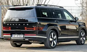 Nowy Hyundai Santa Fe 2025 w czarnym kolorze, z napisem "hybrid" na tyle.