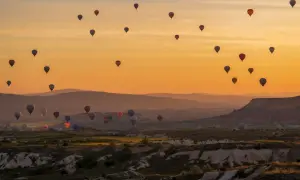 Kapadocja wita wschodem słońca. Dziesiątki kolorowych balonów unoszą się nad malowniczym krajobrazem, tworząc magiczny widok.