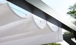 Vit markisduk hänger i vågor under en mörk pergola, perfekt för en solig dag.