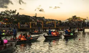 Boote mit bunten Laternen auf einem Fluss in Vietnam bei Sonnenuntergang. Ein toller Tipp für deine Vietnam Reise!