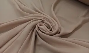 Delikatna, beżowa żorżeta układa się w miękkie fałdy, tworząc elegancką spiralę.