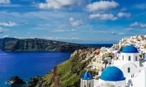 Santorini w maju: błękitne kopuły kościołów, białe domy na klifie i lazurowe morze. Idealna pogoda na zwiedzanie.