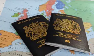 Dwa brytyjskie paszporty leżą na mapie Europy, sugerując podróż. Czy do Wielkiej Brytanii potrzebny jest paszport? Tak, dla większości podróżnych.