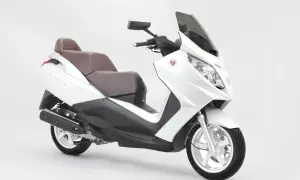 Biały skuter Peugeot Satelis z brązową kanapą, gotowy na miejskie podróże.