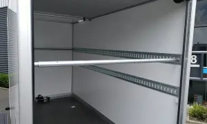 Intérieur de remorque avec rails d'arrimage et barre transversale, idéal pour le règlement chargement remorque.