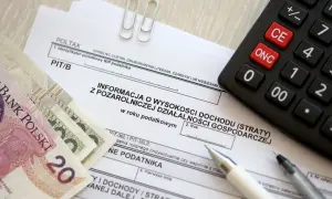 Polskie banknoty, kalkulator i formularz PIT/B. Kto to rezydent podatkowy? To osoba, która rozlicza się z dochodów w Polsce.