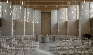 Innenraum einer modernen Kirche mit Reihen von Holzbänken, einem goldenen Kreuz und vielen hängenden Lichtern.